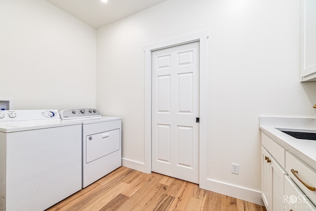 9401 Collett Rd, Robert Lee, TX 76945 - laundry area featuring washing machine and dryer, light wood-type flooring, and cabinet space