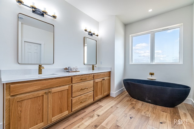 9401 Collett Rd, Robert Lee, TX 76945 - full bathroom featuring double vanity, wood finished floors, a soaking tub, and recessed lighting