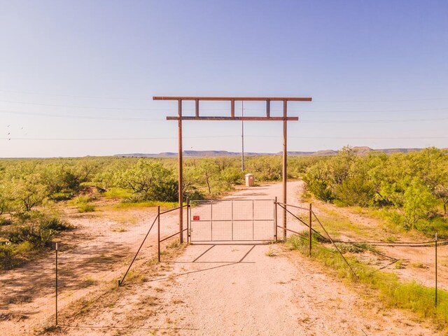 9401 Collett Rd, Robert Lee, TX 76945 - view of dirt / gravel road with a gate, a view of rural / pastoral area, and a gated entry
