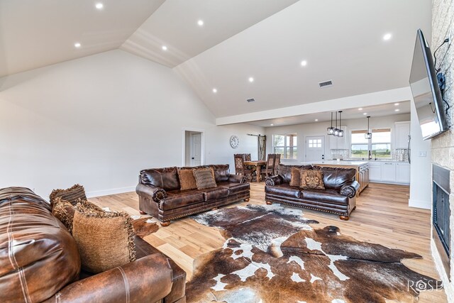 9401 Collett Rd, Robert Lee, TX 76945 - living room featuring high vaulted ceiling, light wood-style flooring, a fireplace, and recessed lighting