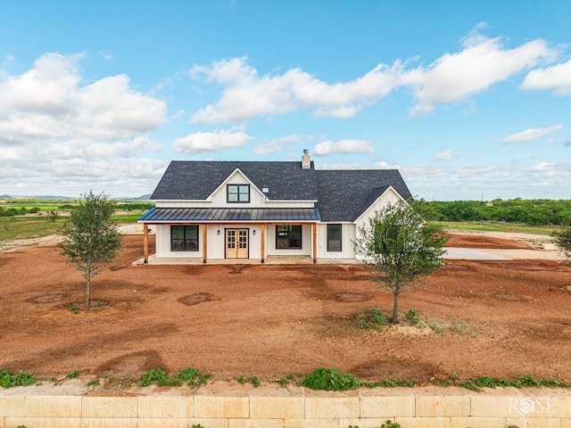 9401 Collett Rd, Robert Lee, TX 76945 - modern inspired farmhouse featuring a standing seam roof, a metal roof, covered porch, a chimney, and french doors
