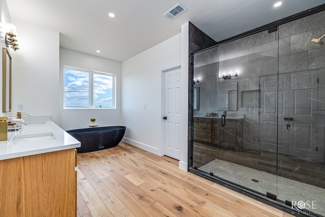 9401 Collett Rd, Robert Lee, TX 76945 - bathroom with a freestanding bath, a shower stall, double vanity, wood finished floors, and recessed lighting