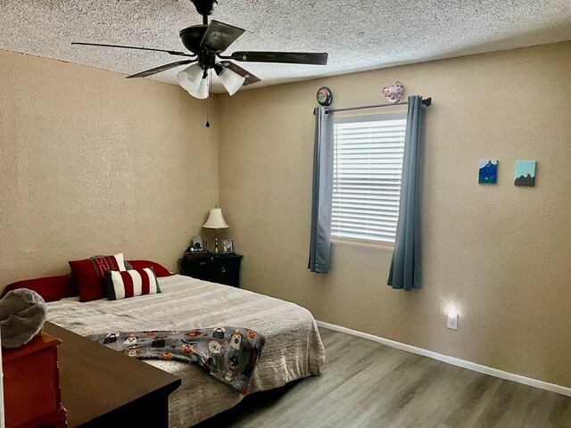 201 N Franklin St, Bronte, TX 76933 - bedroom featuring wood finished floors, a textured wall, baseboards, and a ceiling fan
