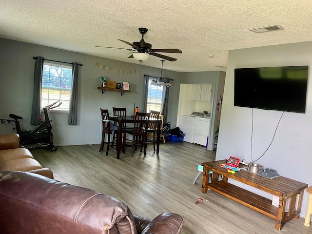 201 N Franklin St, Bronte, TX 76933 - living area featuring washer and dryer, a ceiling fan, plenty of natural light, wood finished floors, and a textured ceiling