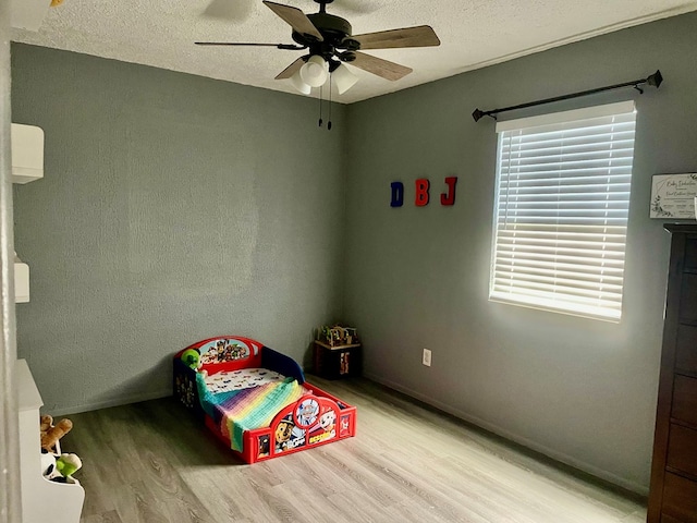 201 N Franklin St, Bronte, TX 76933 - bedroom with light wood finished floors, baseboards, a ceiling fan, and a textured ceiling