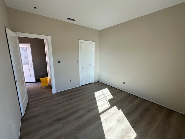 unfurnished bedroom with visible vents and wood finished floors