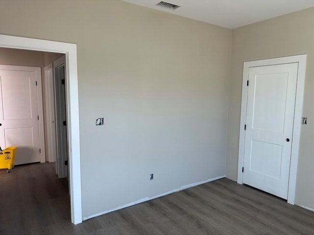 unfurnished room with visible vents and wood finished floors