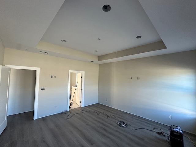 spare room with visible vents, a raised ceiling, and wood finished floors