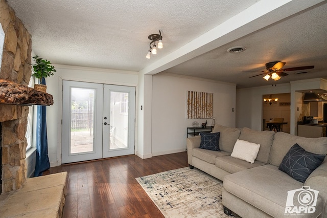 living room with french doors, a textured ceiling, visible vents, and wood-type flooring
