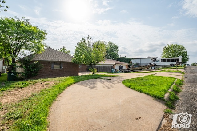 view of front of property featuring brick siding, roof with shingles, and concrete driveway