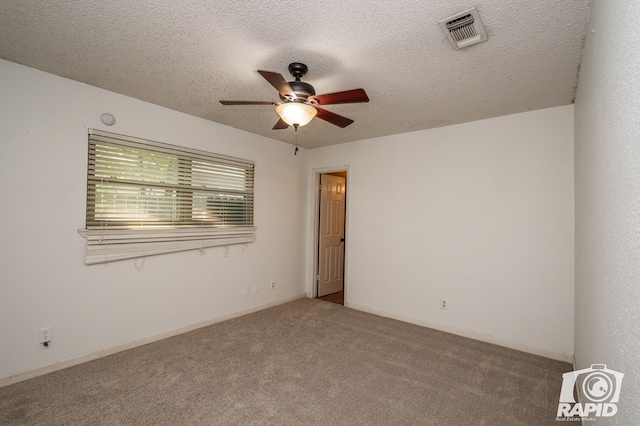 spare room featuring a ceiling fan, a textured ceiling, visible vents, and carpet