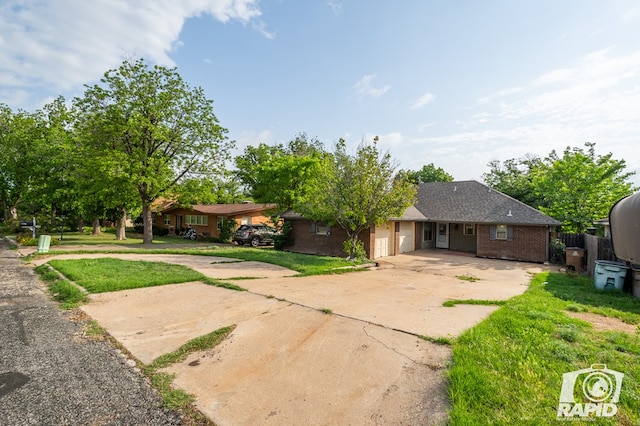 1016 N Adams Ave, San Angelo, TX 76901 - ranch-style house featuring a garage, a front lawn, fence, brick siding, and driveway