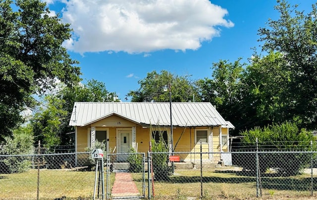 15E 24th St, San Angelo, TX 76903 - view of front of property featuring a fenced front yard, a gate, a porch, and a metal roof