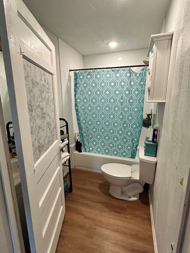 15E 24th St, San Angelo, TX 76903 - full bath with wood finished floors, shower / bath combo with shower curtain, and a textured ceiling