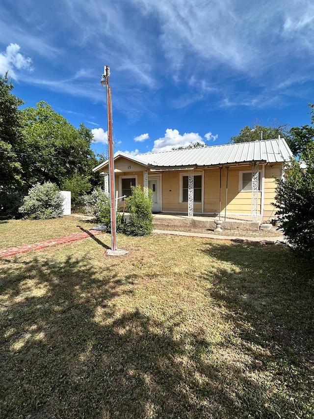15E 24th St, San Angelo, TX 76903 - back of property featuring a yard, covered porch, and a metal roof