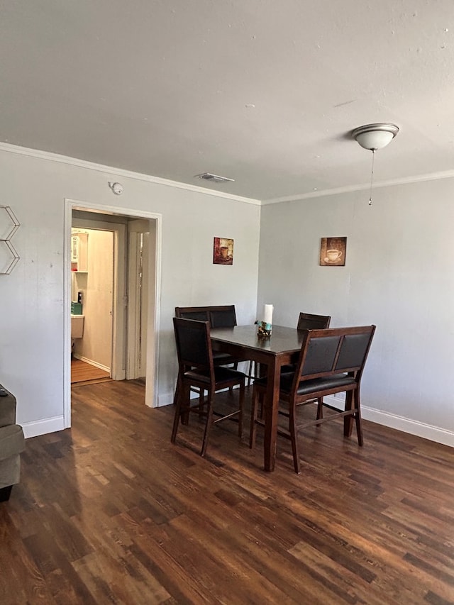 15E 24th St, San Angelo, TX 76903 - dining room featuring crown molding and dark wood-style flooring