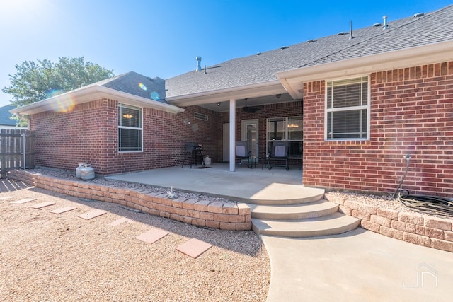 3067 Champions Cir, San Angelo, TX 76904 - back of property featuring roof with shingles, brick siding, and a patio