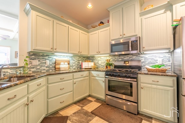 3067 Champions Cir, San Angelo, TX 76904 - kitchen with stainless steel appliances, a sink, decorative backsplash, dark stone counters, and recessed lighting