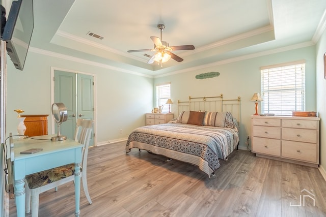 3067 Champions Cir, San Angelo, TX 76904 - bedroom featuring a tray ceiling, light wood finished floors, baseboards, ornamental molding, and a ceiling fan