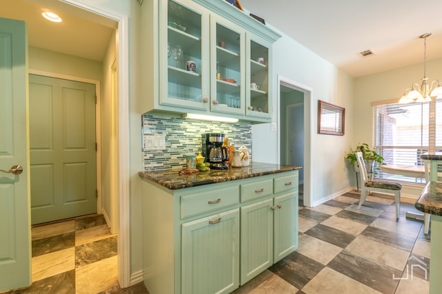 3067 Champions Cir, San Angelo, TX 76904 - kitchen with green cabinetry, backsplash, a chandelier, glass insert cabinets, and baseboards