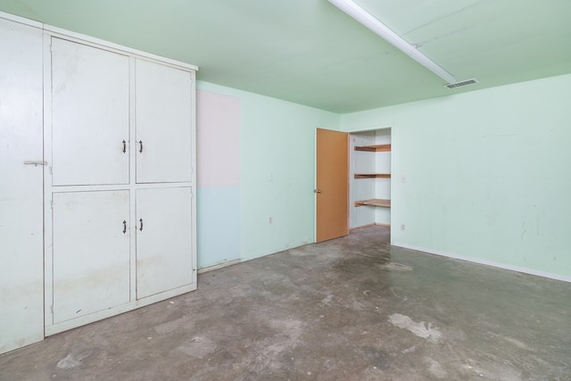 unfurnished bedroom with unfinished concrete floors and visible vents