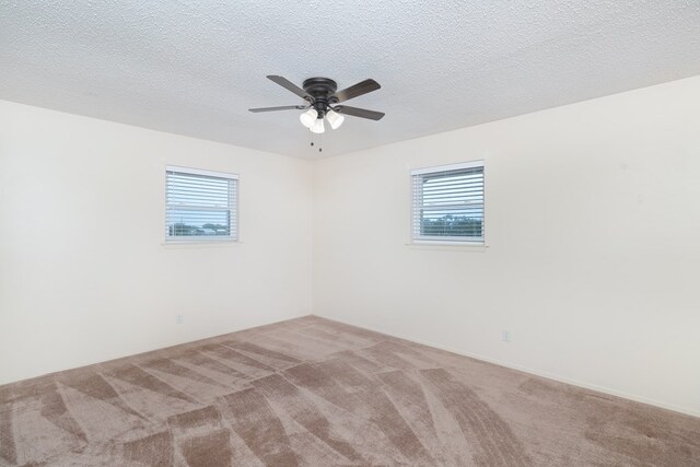 carpeted spare room with a ceiling fan and a healthy amount of sunlight