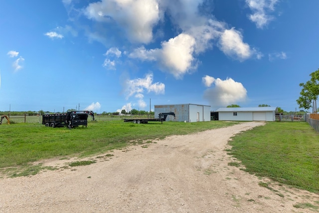view of road featuring a rural view, an outbuilding, and dirt driveway