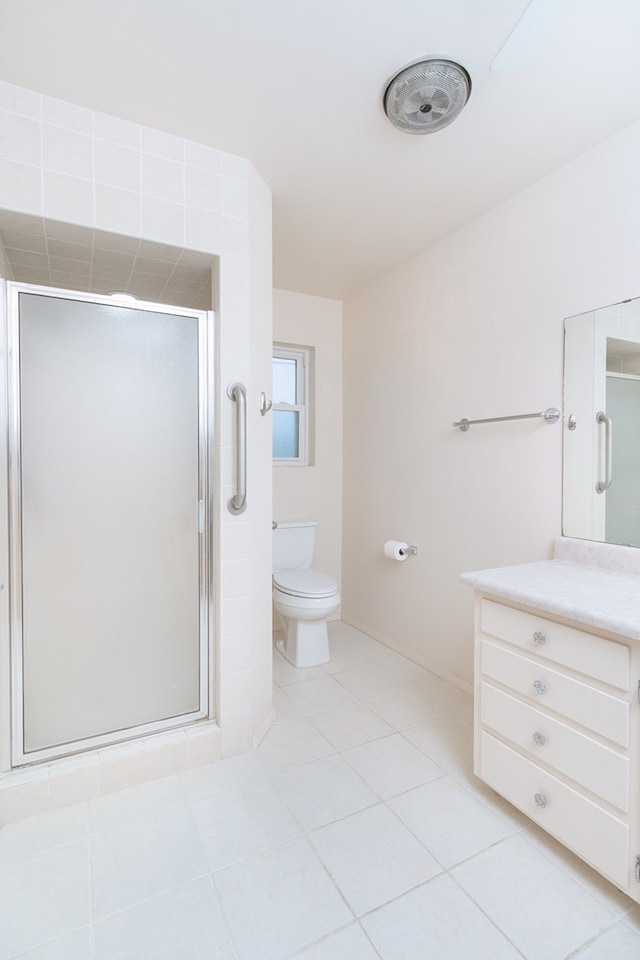 bathroom featuring toilet, baseboards, tile patterned flooring, and a stall shower