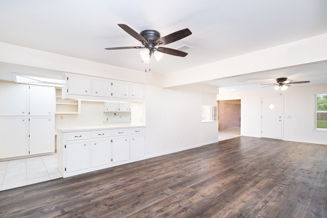 unfurnished living room featuring ceiling fan, dark wood finished floors, and visible vents