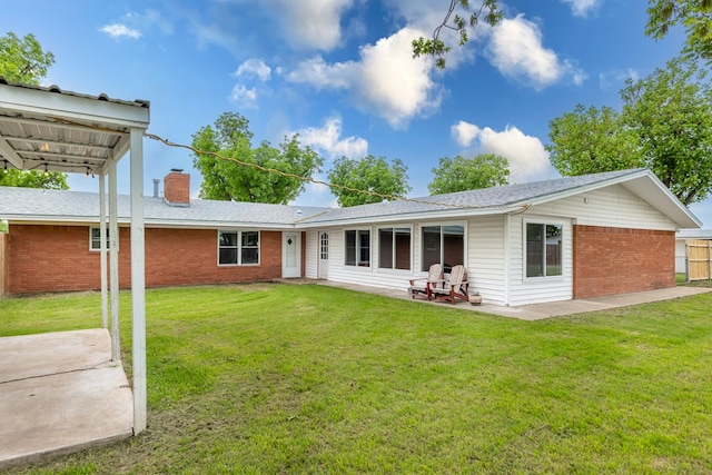 back of house with brick siding, a chimney, a lawn, and a patio