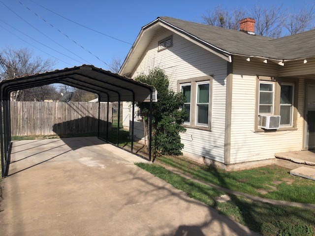 view of property exterior featuring cooling unit and a carport