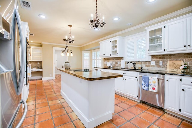 5413 Bent Oak Ct, San Angelo, TX 76904 - kitchen with appliances with stainless steel finishes, a chandelier, a center island, decorative backsplash, and crown molding
