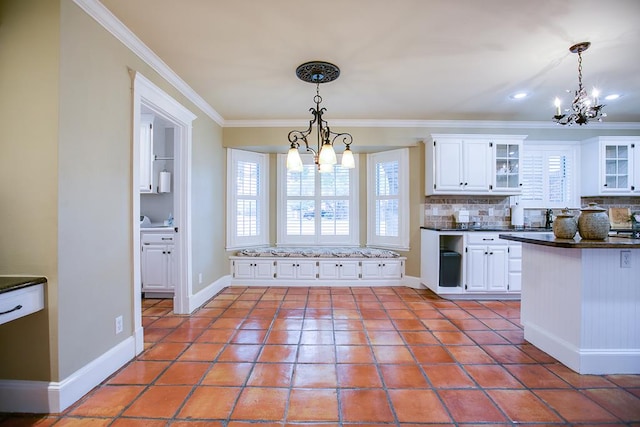 5413 Bent Oak Ct, San Angelo, TX 76904 - kitchen featuring a chandelier, decorative backsplash, dark countertops, crown molding, and white cabinets
