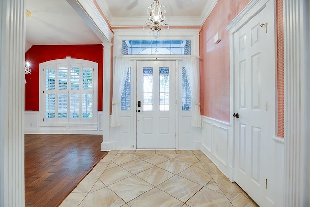 5413 Bent Oak Ct, San Angelo, TX 76904 - foyer entrance featuring a decorative wall, a chandelier, crown molding, wainscoting, and light wood-style floors