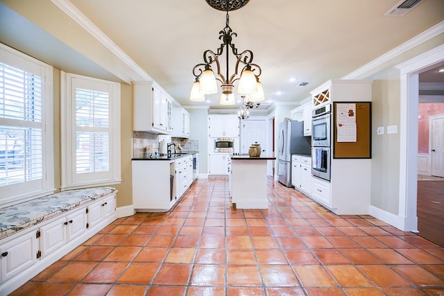 5413 Bent Oak Ct, San Angelo, TX 76904 - kitchen with a chandelier, stainless steel appliances, ornamental molding, backsplash, and white cabinets