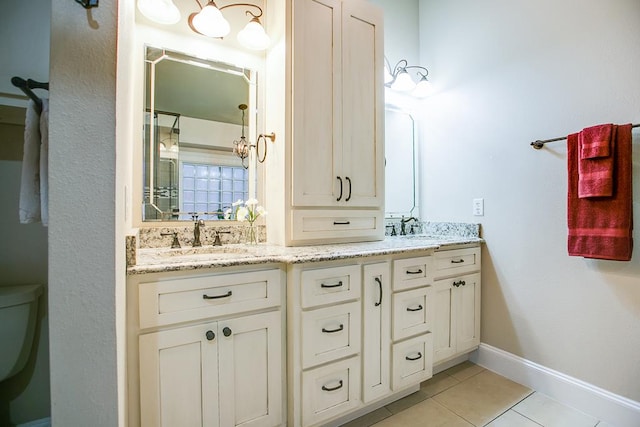 5413 Bent Oak Ct, San Angelo, TX 76904 - full bathroom featuring tile patterned flooring, double vanity, toilet, and baseboards