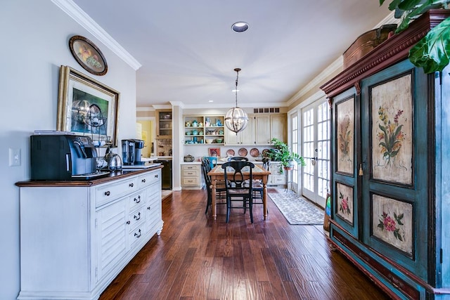 dining space with crown molding, dark hardwood / wood-style floors, an inviting chandelier, and french doors