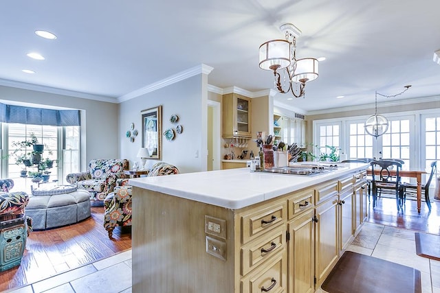 kitchen with hanging light fixtures, crown molding, a center island, and light tile patterned flooring