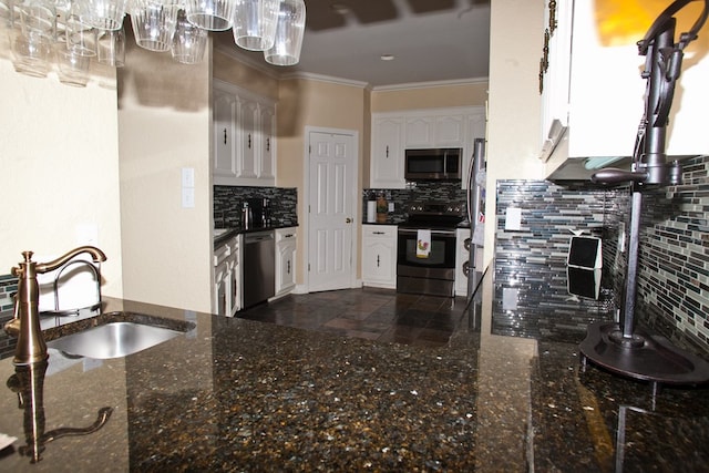 5114 Fairway Dr, San Angelo, TX 76904 - kitchen with appliances with stainless steel finishes, a sink, white cabinets, backsplash, and ornamental molding