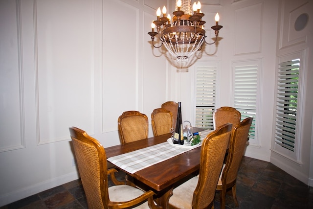 5114 Fairway Dr, San Angelo, TX 76904 - dining room featuring a chandelier, dark stone finish floors, baseboards, and a decorative wall