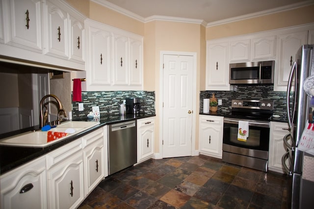 5114 Fairway Dr, San Angelo, TX 76904 - kitchen with stainless steel appliances, dark countertops, white cabinetry, crown molding, and decorative backsplash