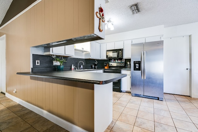 kitchen with black appliances, a textured ceiling, white cabinets, light tile patterned flooring, and kitchen peninsula