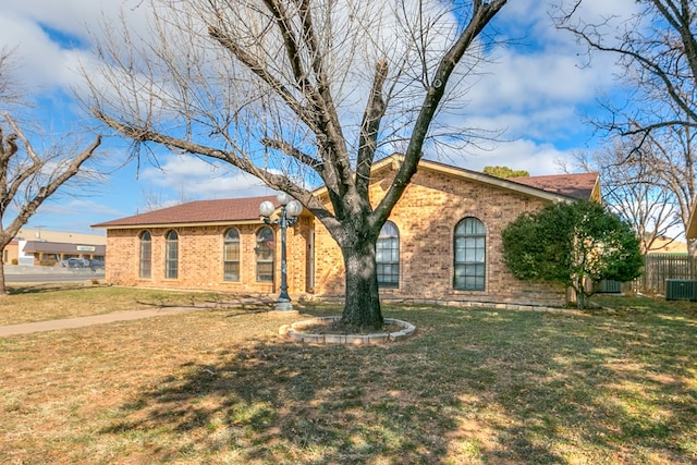 ranch-style house featuring a front yard and central AC unit