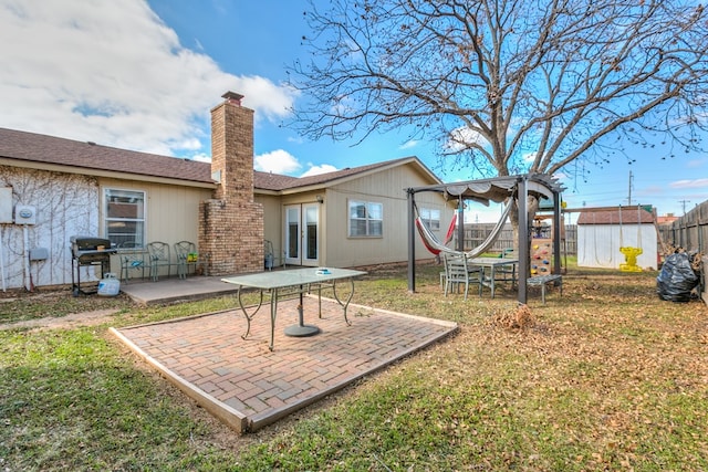 back of property with a lawn, a patio area, a shed, and a pergola