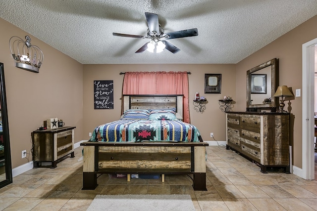 bedroom with ceiling fan, tile patterned floors, and a textured ceiling