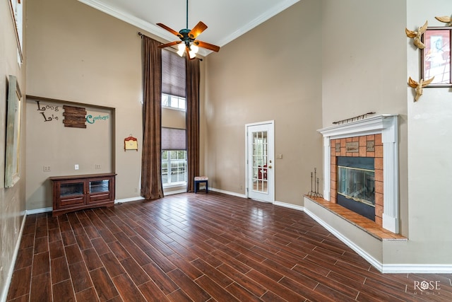unfurnished living room with baseboards, a ceiling fan, crown molding, a tile fireplace, and wood finished floors