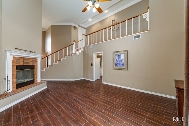 unfurnished living room with ceiling fan, baseboards, a glass covered fireplace, and wood tiled floor