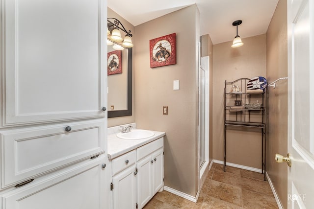 bathroom featuring baseboards, a shower stall, and vanity