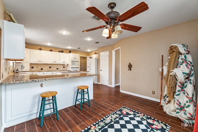 kitchen featuring white appliances, visible vents, and wood tiled floor