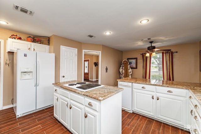 kitchen featuring visible vents, white appliances, and wood finish floors